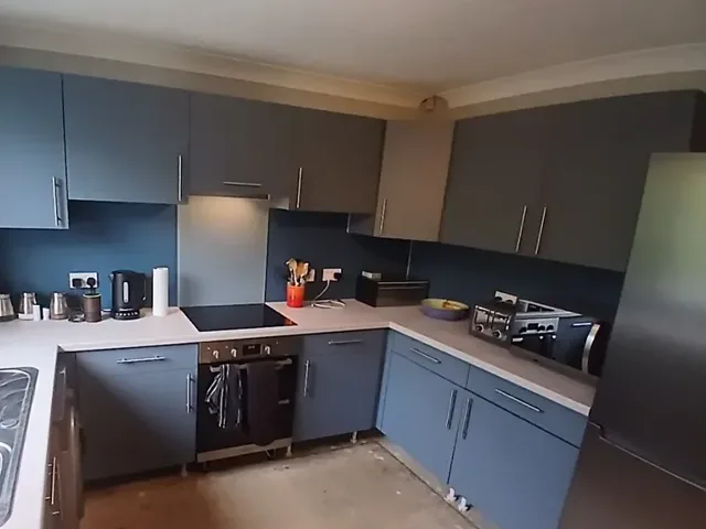 After: the same kitchen wrapped in two-tone blue and grey