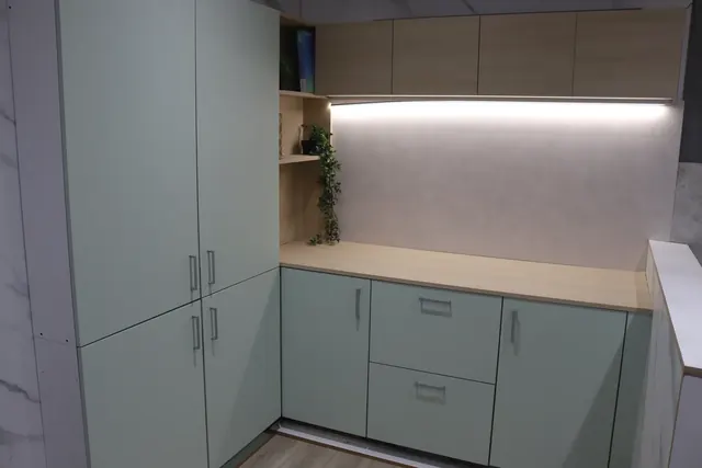 Sage green wrapped kitchen with oak-effect worktops in our Cambuslang showroom